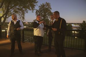 Wedding guests gathered on balcony during golden hour celebrations.