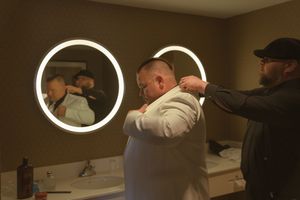 Wedding party posing in front of illuminated circular mirrors in dimly lit room.