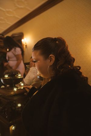 Side profile view of a guest in formal attire at an evening wedding reception.