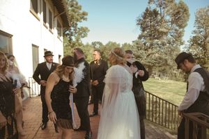 Wedding party gathers on outdoor terrace during sunset celebration.