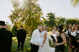 Wedding party enjoys candid moments together during outdoor photo session.