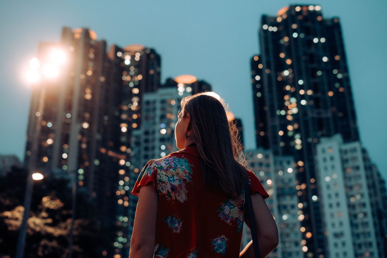 Woman looking at the Hong Kong city skyscrapers at twilight