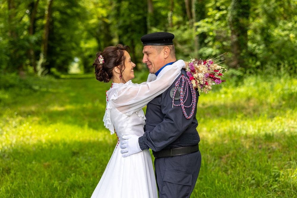 Romantic spring garden wedding portraits with flowering trees in the background.