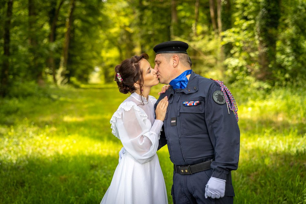Tender moment captured during an outdoor wedding photoshoot in a lush green setting.