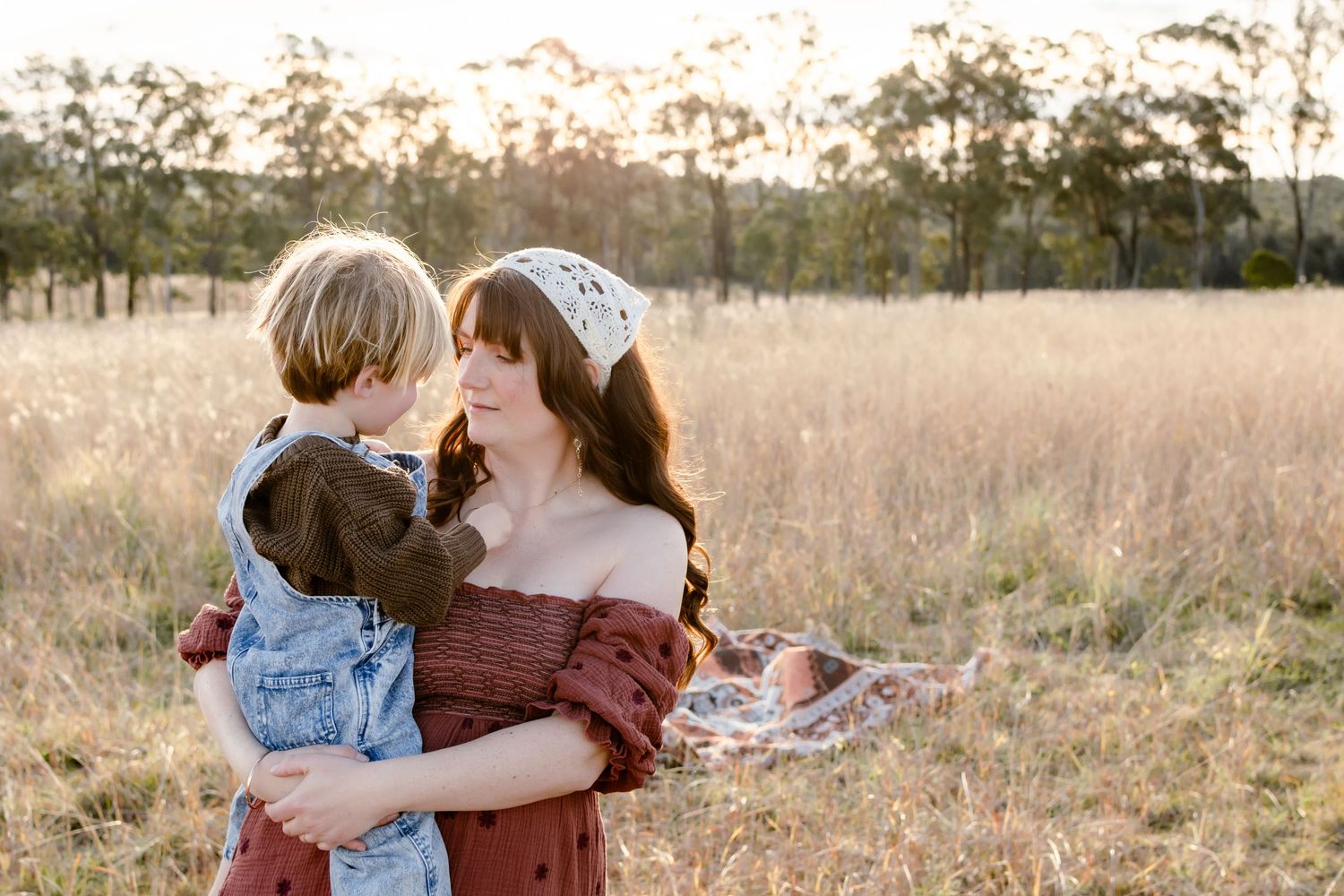 Newcastle Family Photographer captured mother holding baby at golden hour at the beach