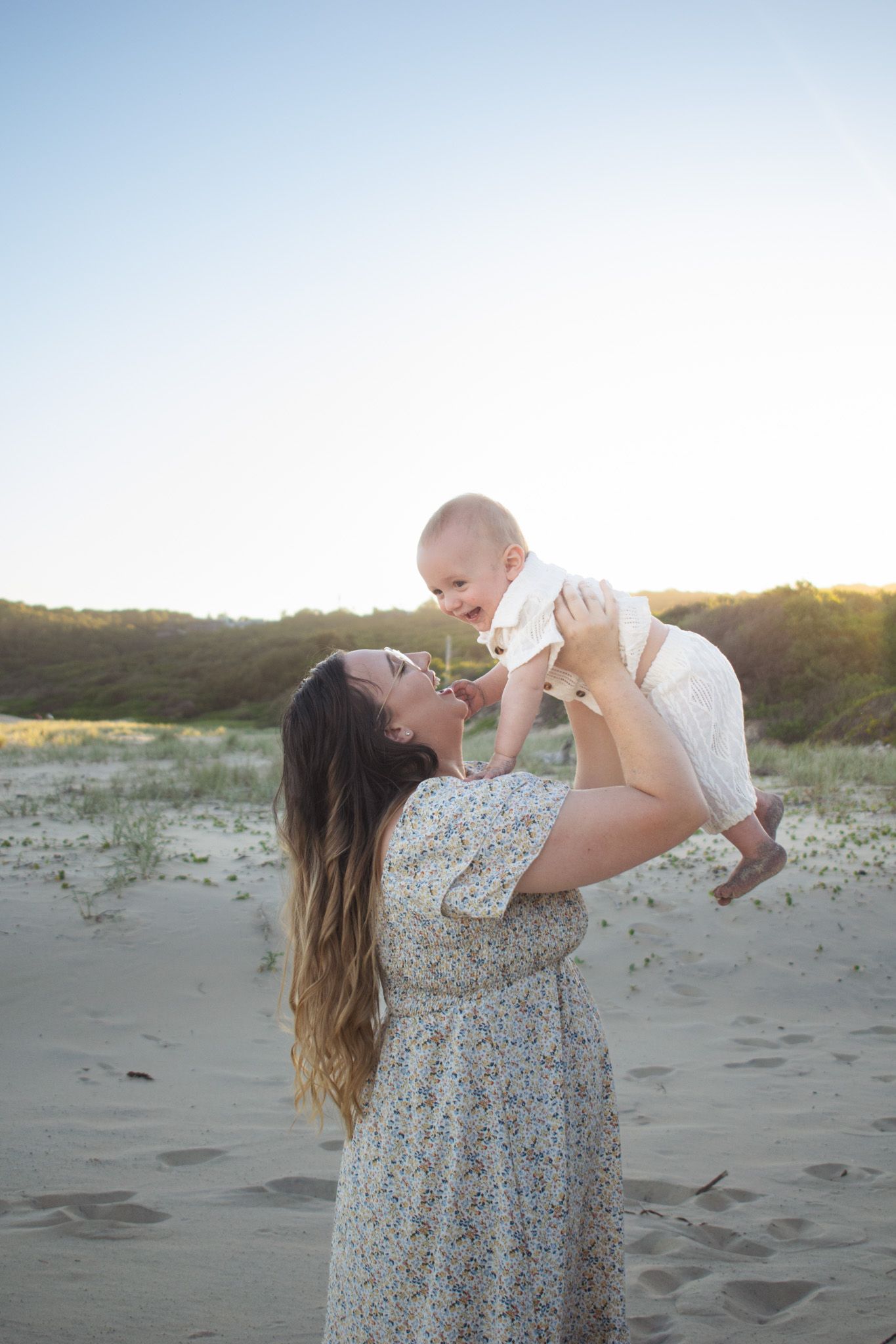 Newcastle Family Photographer captured mother holding baby at golden hour at the beach