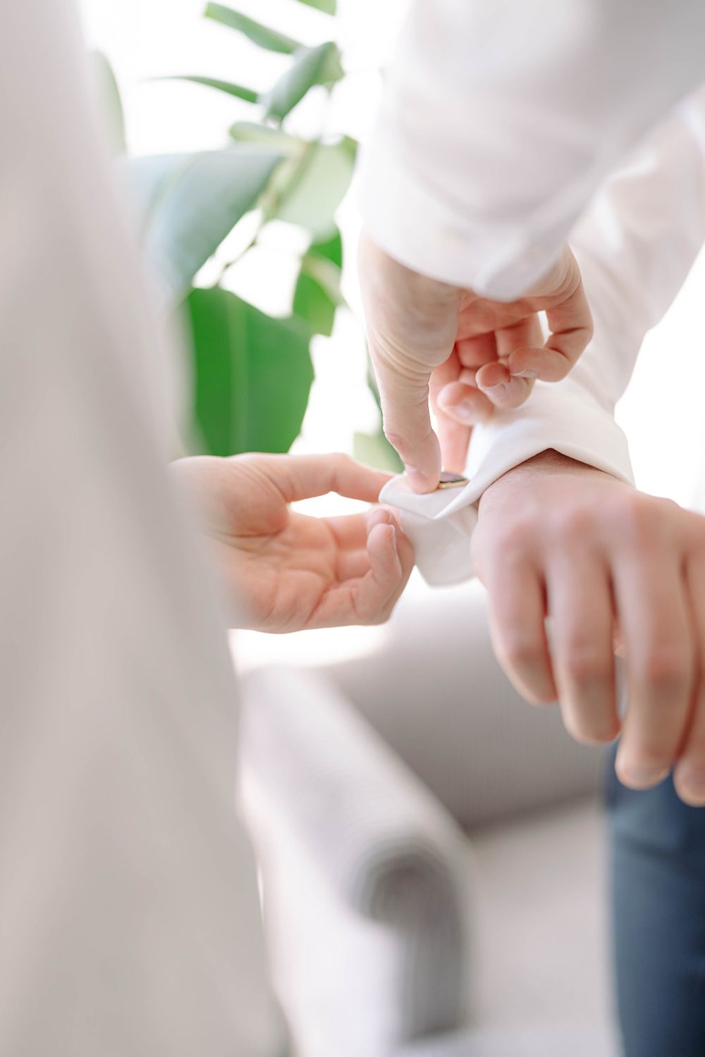 Close-up of hands adjusting formal white shirt cuffs.