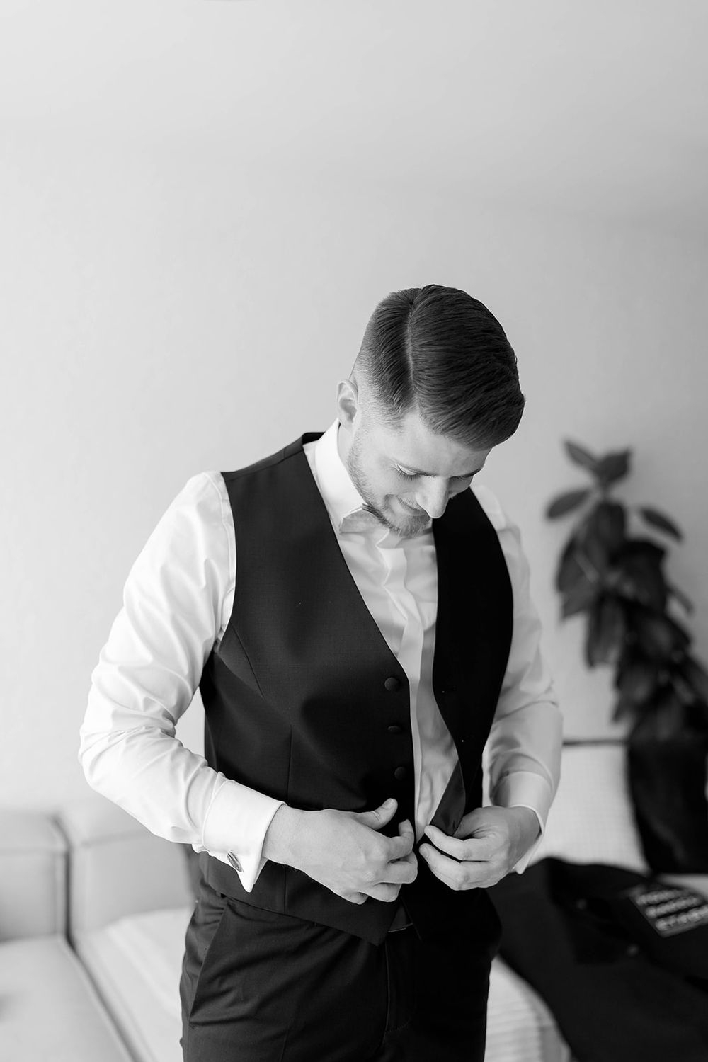 A sequence of black and white photos showing someone adjusting a formal black vest and white shirt.