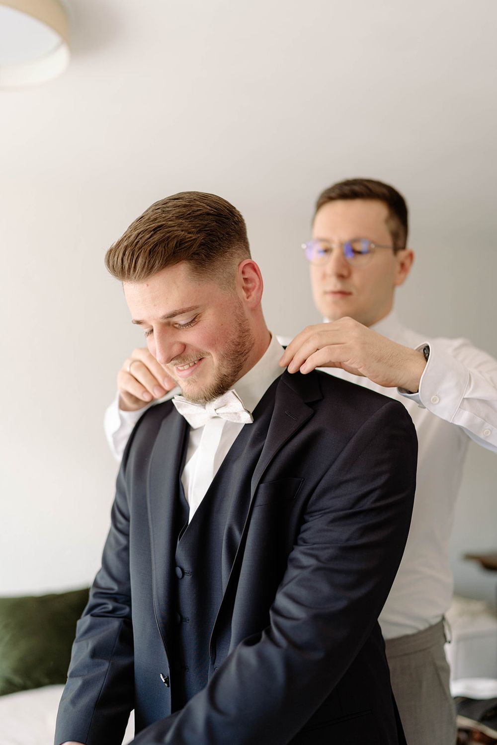 Getting ready sequence showing formal attire adjustments in a bright room.