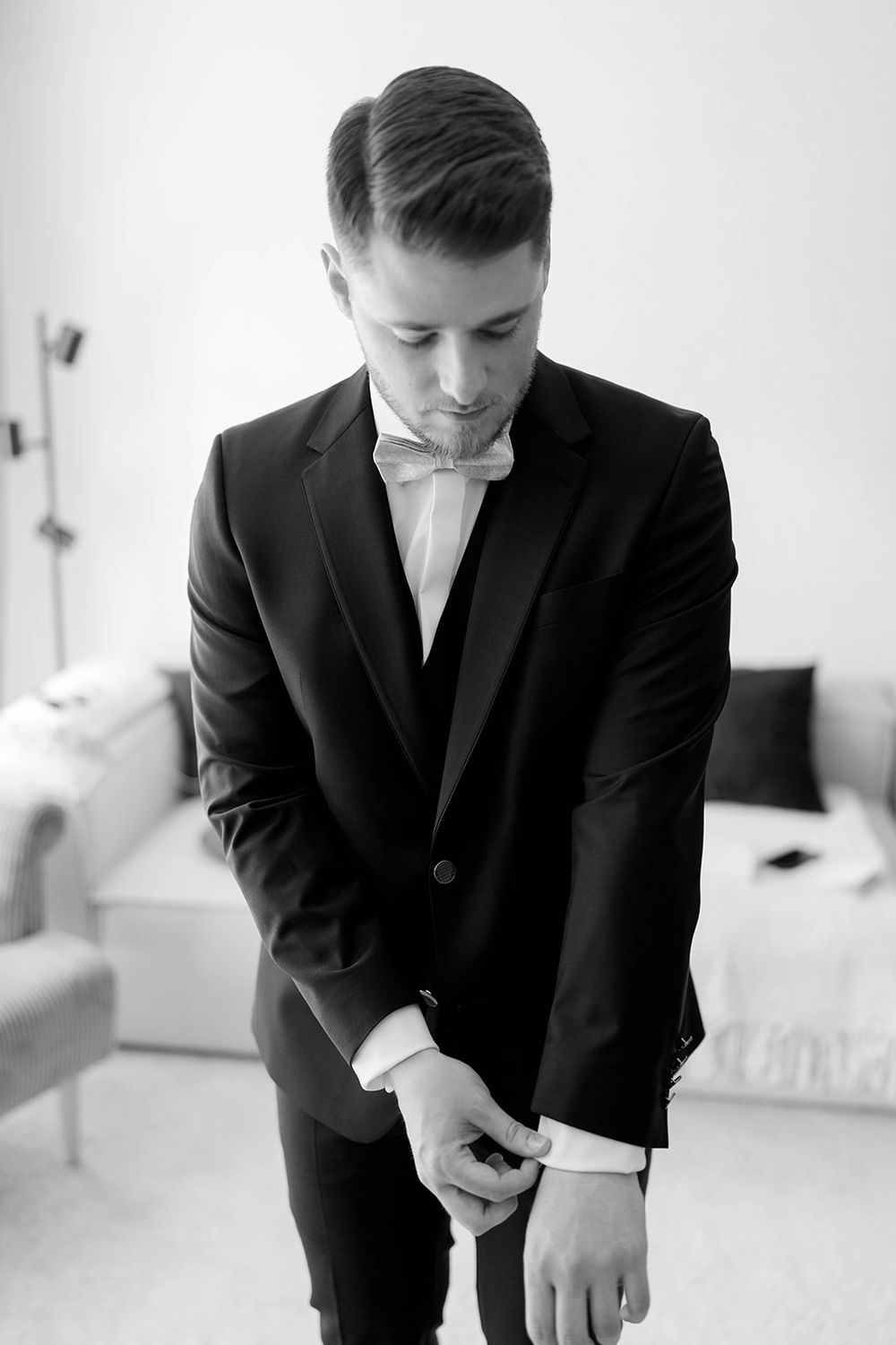 Series of photos capturing preparation moments in a black suit.