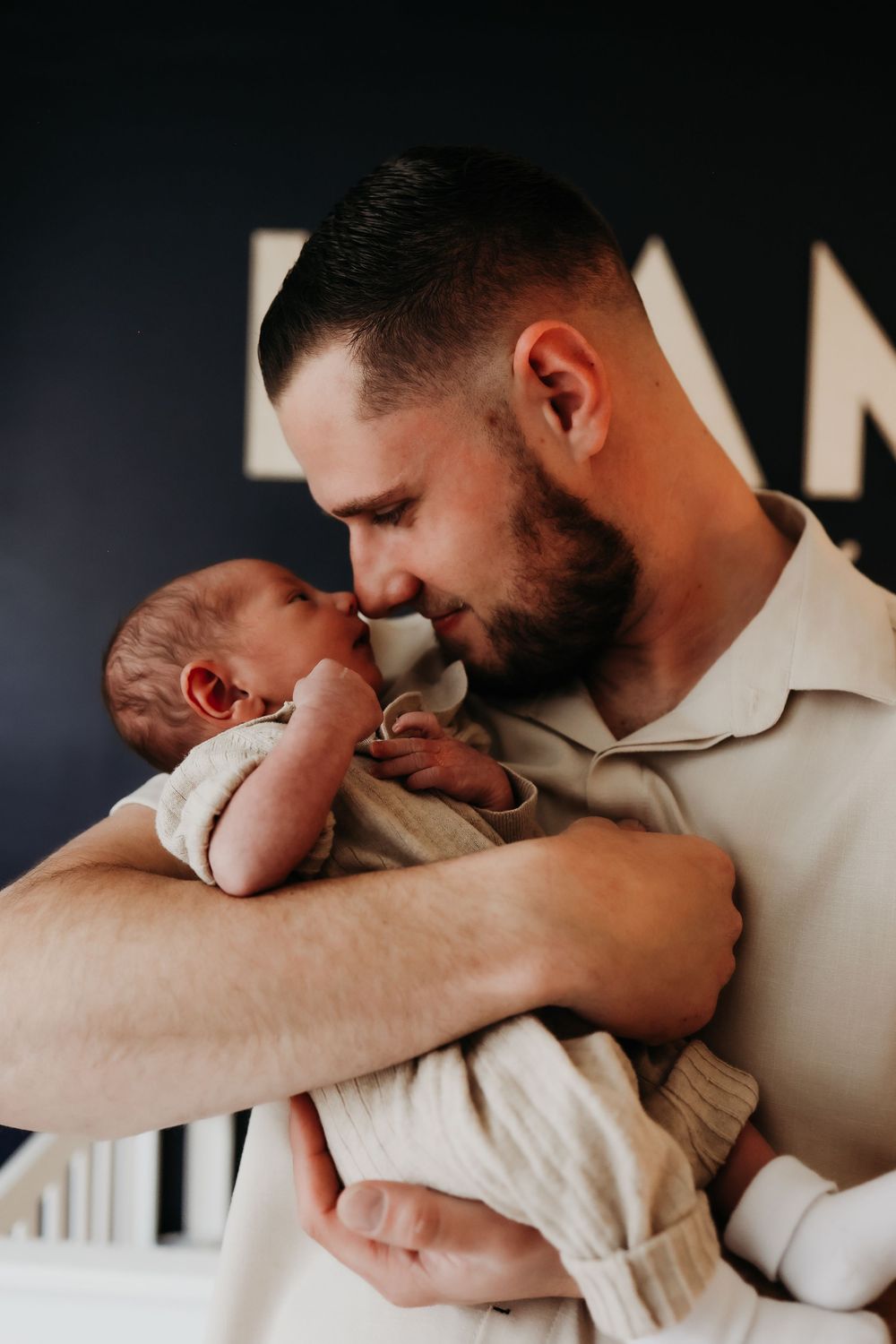 A tender moment between parent and newborn baby captured in a series of intimate black and white photos.