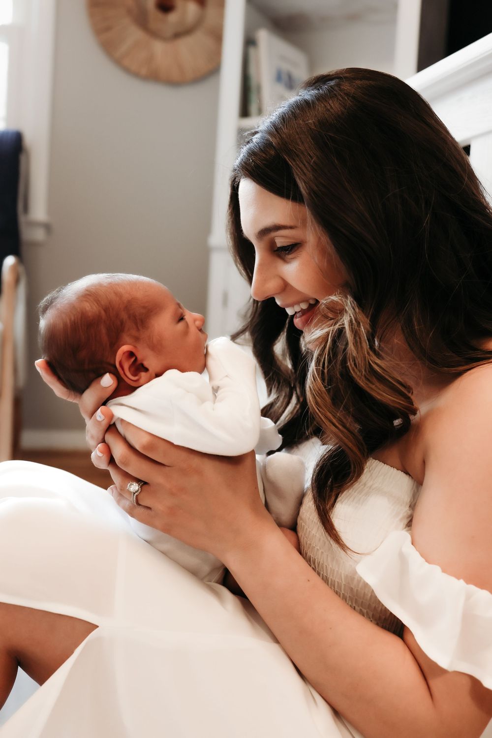 A moment shared between a mother and her newborn as they share smiles and loving glances during newborn shoot in Andover, New Jersey