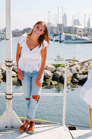 Lifestyle photos on waterfront dock with marina and sailboats in background.