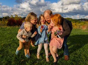 Candid moments of family fun in an outdoor field with dramatic sky and natural lighting.