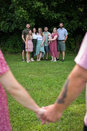 Pink-themed gathering on grassy lawn with group posed in background.