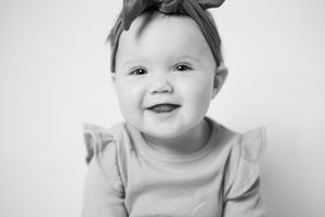 Black and white portrait series of baby with expressive faces against white background.