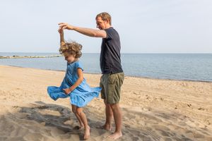 Dancing together on beach with ocean view in background.