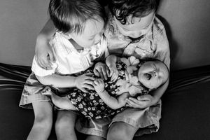 Monochrome series of tender moments with newborn baby being held.