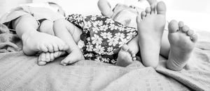 Black and white photography series showing baby's tiny feet and details.