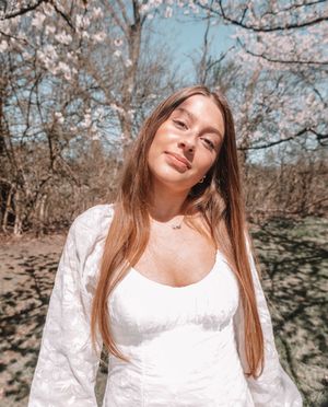 A sunny springtime portrait under blooming cherry blossom trees.