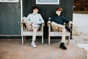 People sitting on wooden benches in a casual outdoor setting.