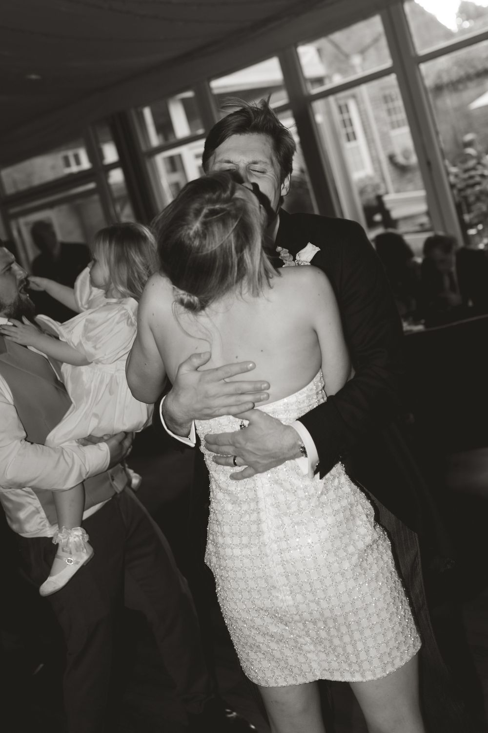 A black and white candid photo of a couple embracing during their first dance at Norwood park in Southwell, nottinghamshire