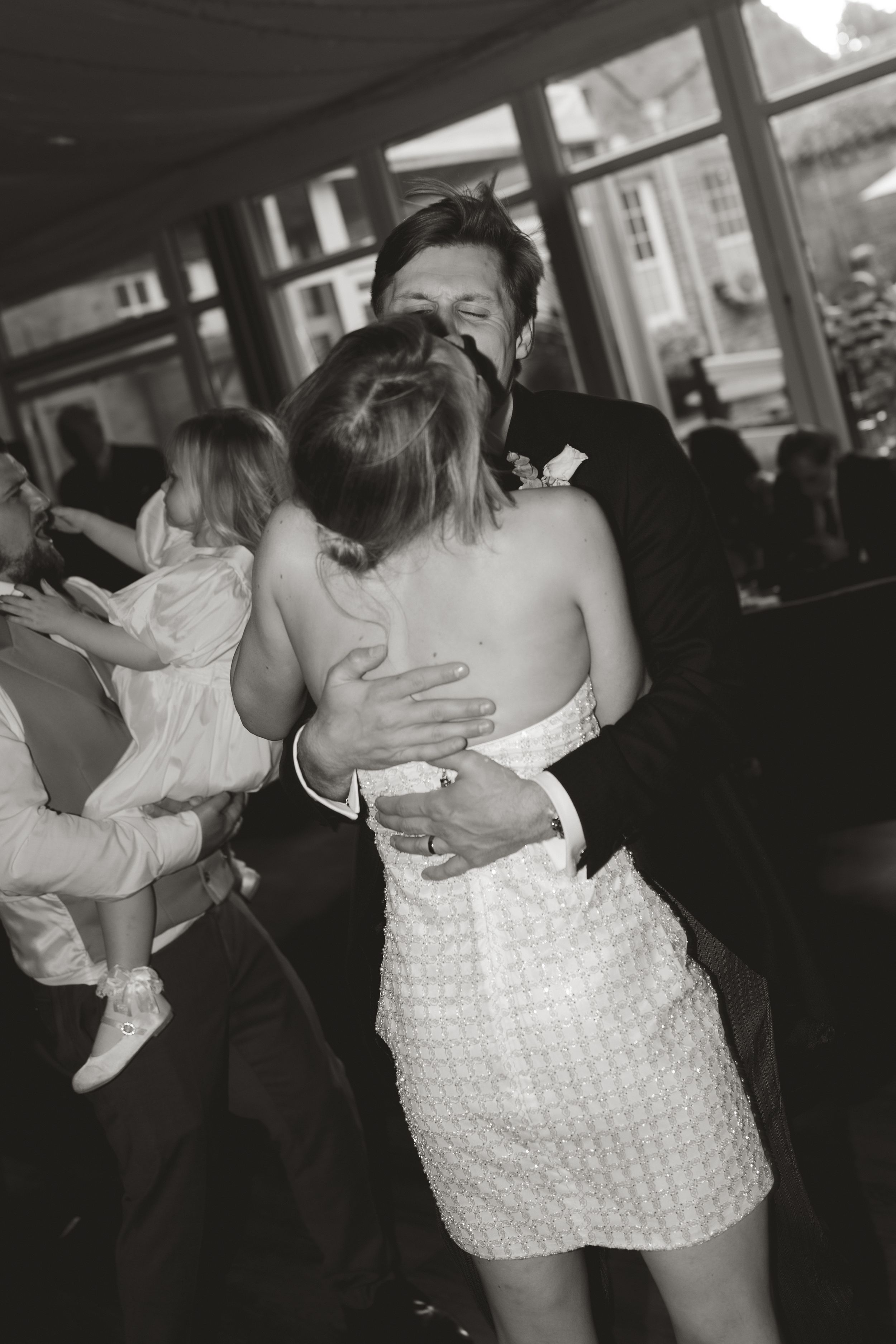 A black and white candid photo of a couple embracing during their first dance at Norwood park in Southwell, nottinghamshire
