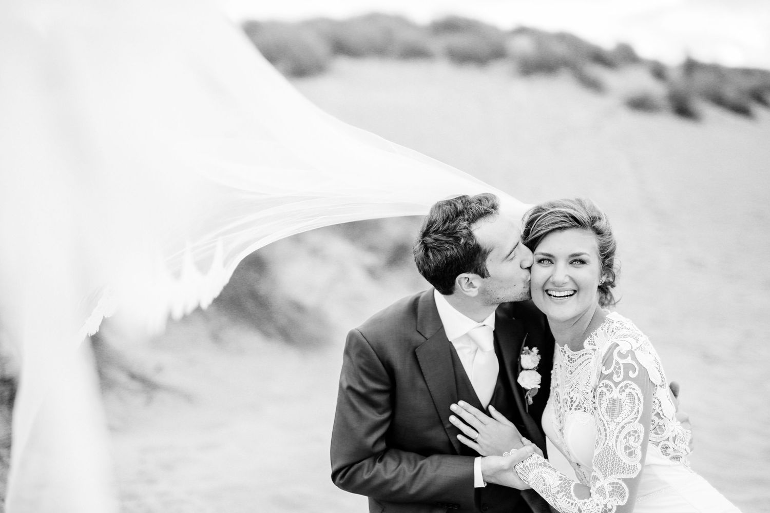 A black and white close-up photo shows a wedding dress draped on the floor. Wedding in Mallorca. Getting ready for a big day.