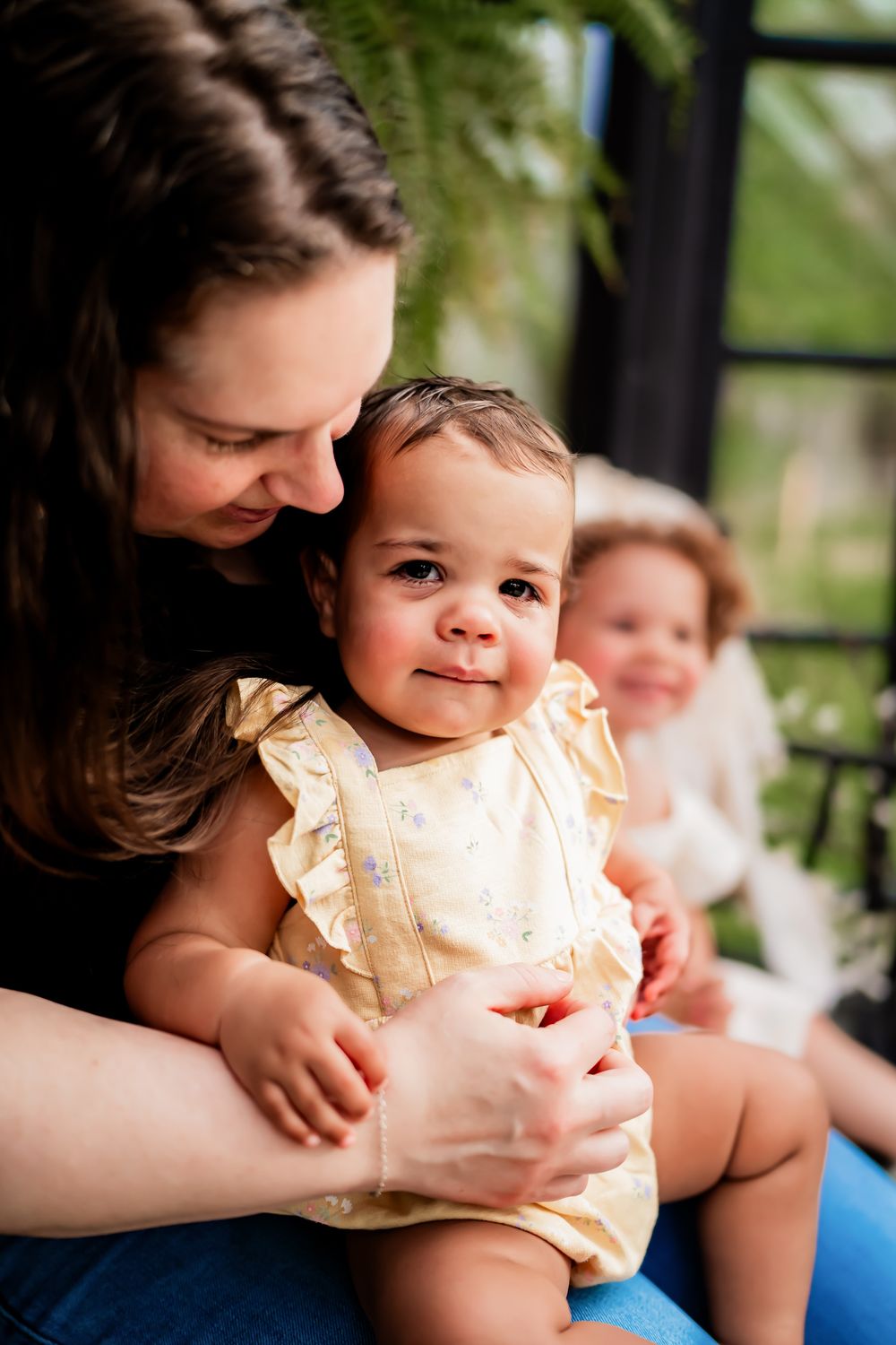 A heartwarming family moment showing cuddles and smiles while sitting together on a porch.