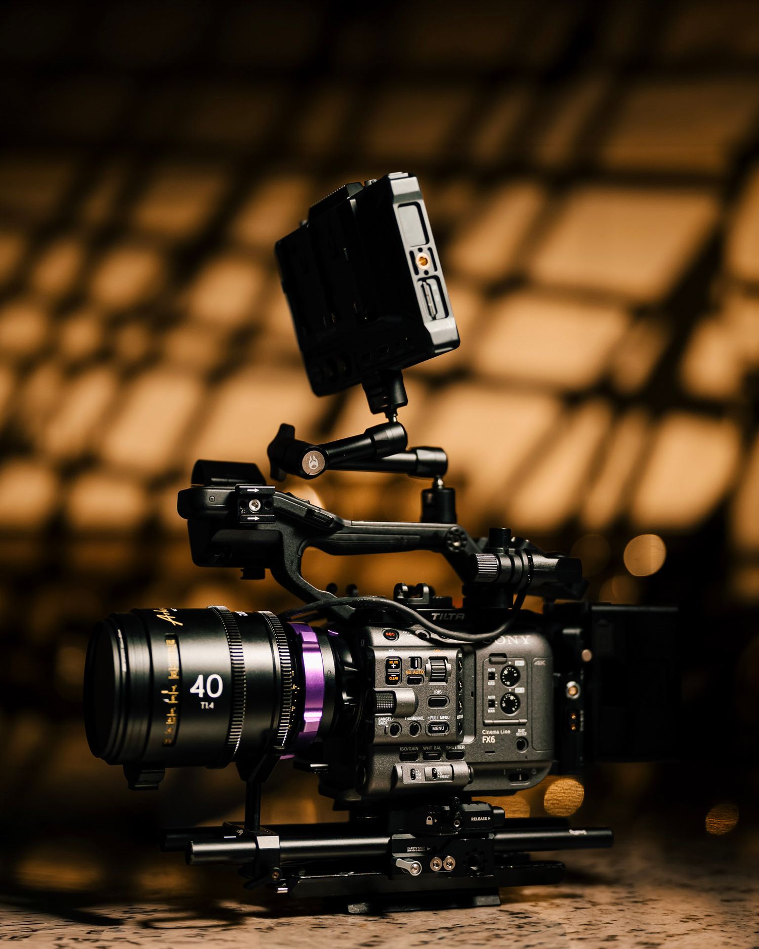 A close-up macro shot of a black Sony camera body showing control buttons and dials in low light.
