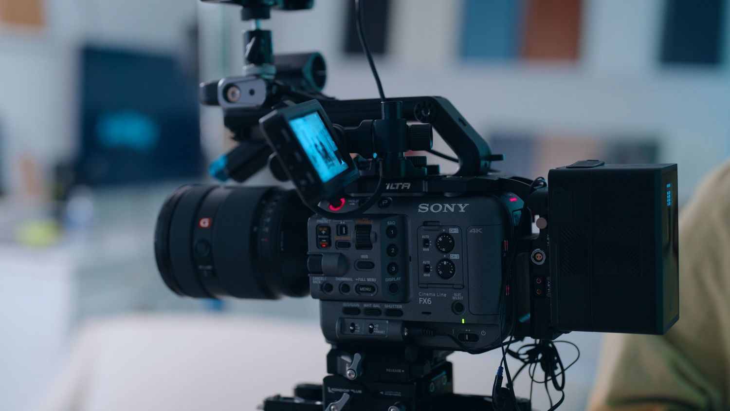 A close-up macro shot of a black Sony camera body showing control buttons and dials in low light.