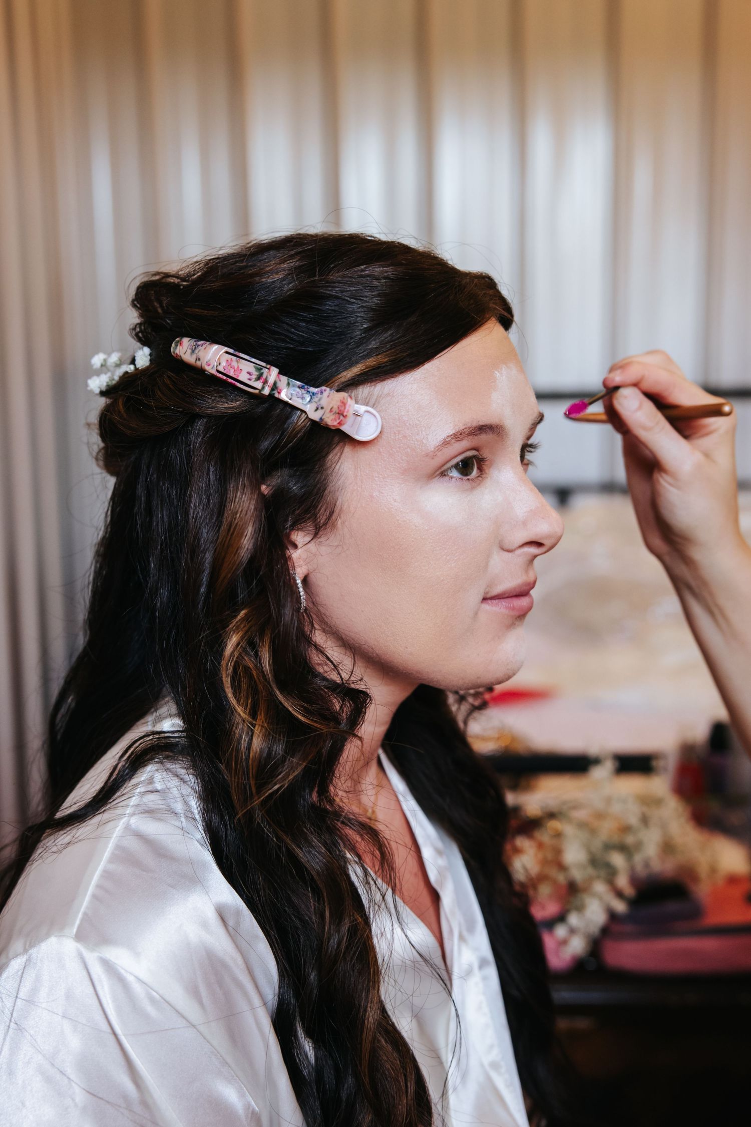 A profession makeup artist applies eye cosmetics to client in white robe during a beauty preparation session. Knoxville wedding photographer