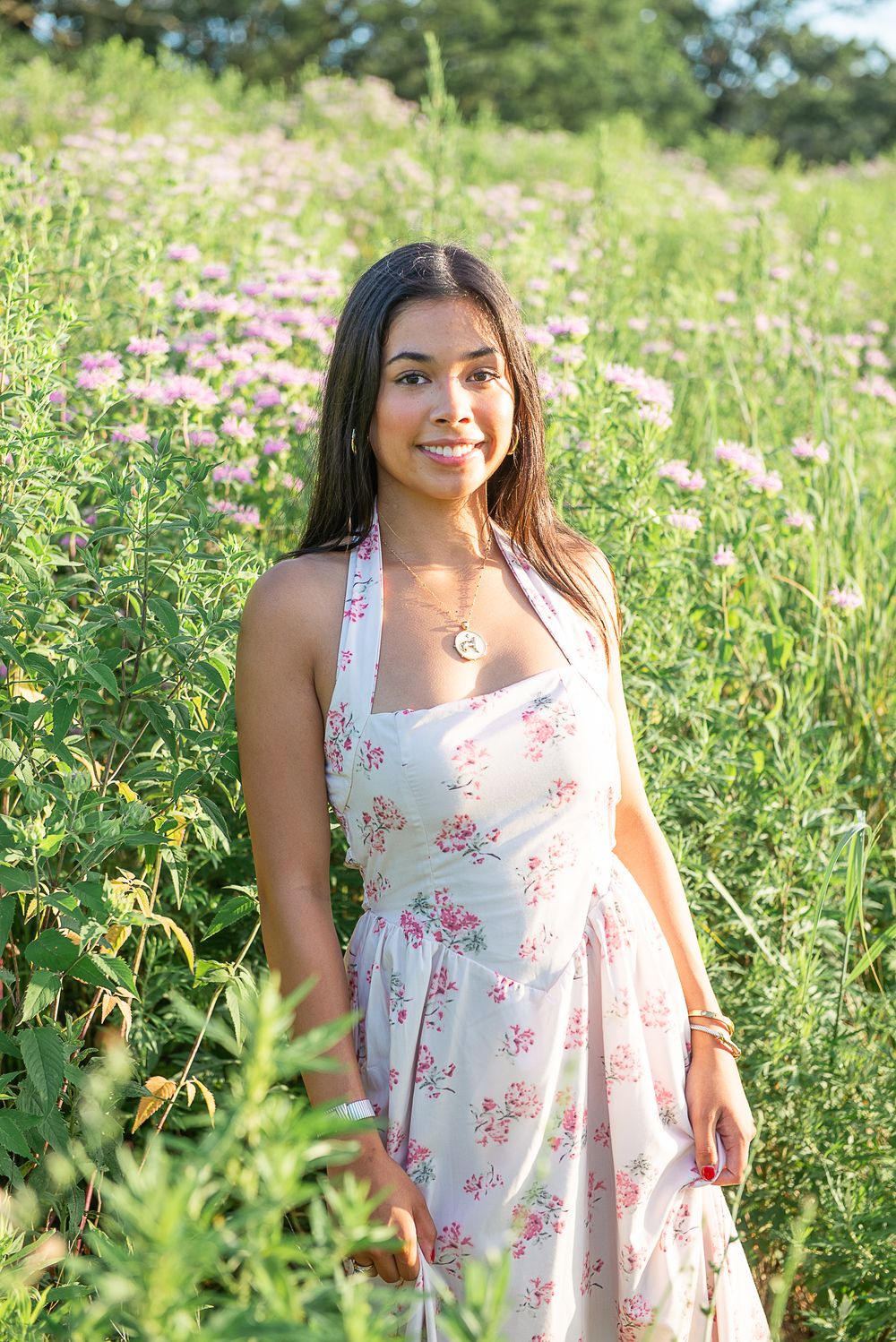 White floral summer dress in blooming wildflower field during golden hour.