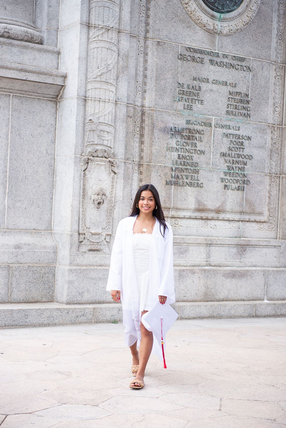 An elegant portrait session against ornate stone architecture with white architectural details.