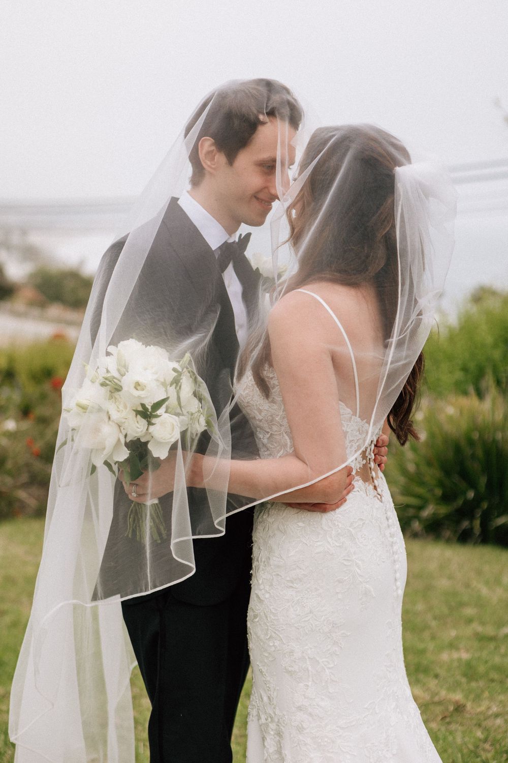 Malibu film photographer shot of the couple under the veil overlooking the Pacific Ocean.
