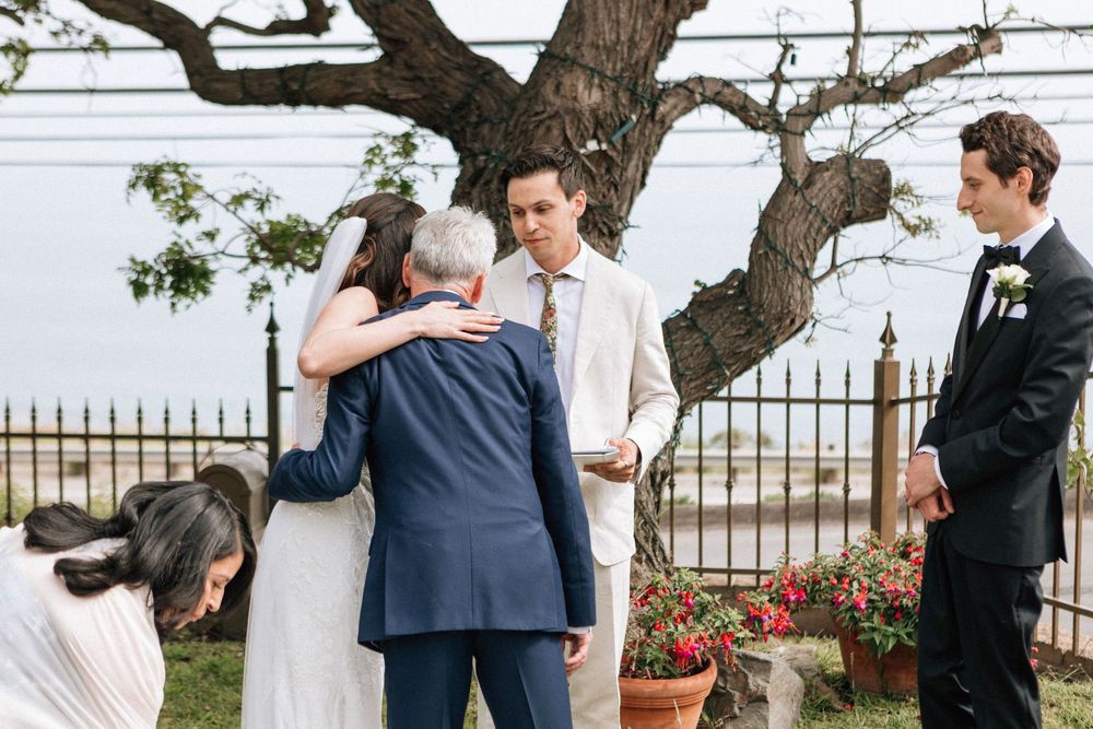 Malibu film photographer capturing the bride hugging her father after the aisle walk.