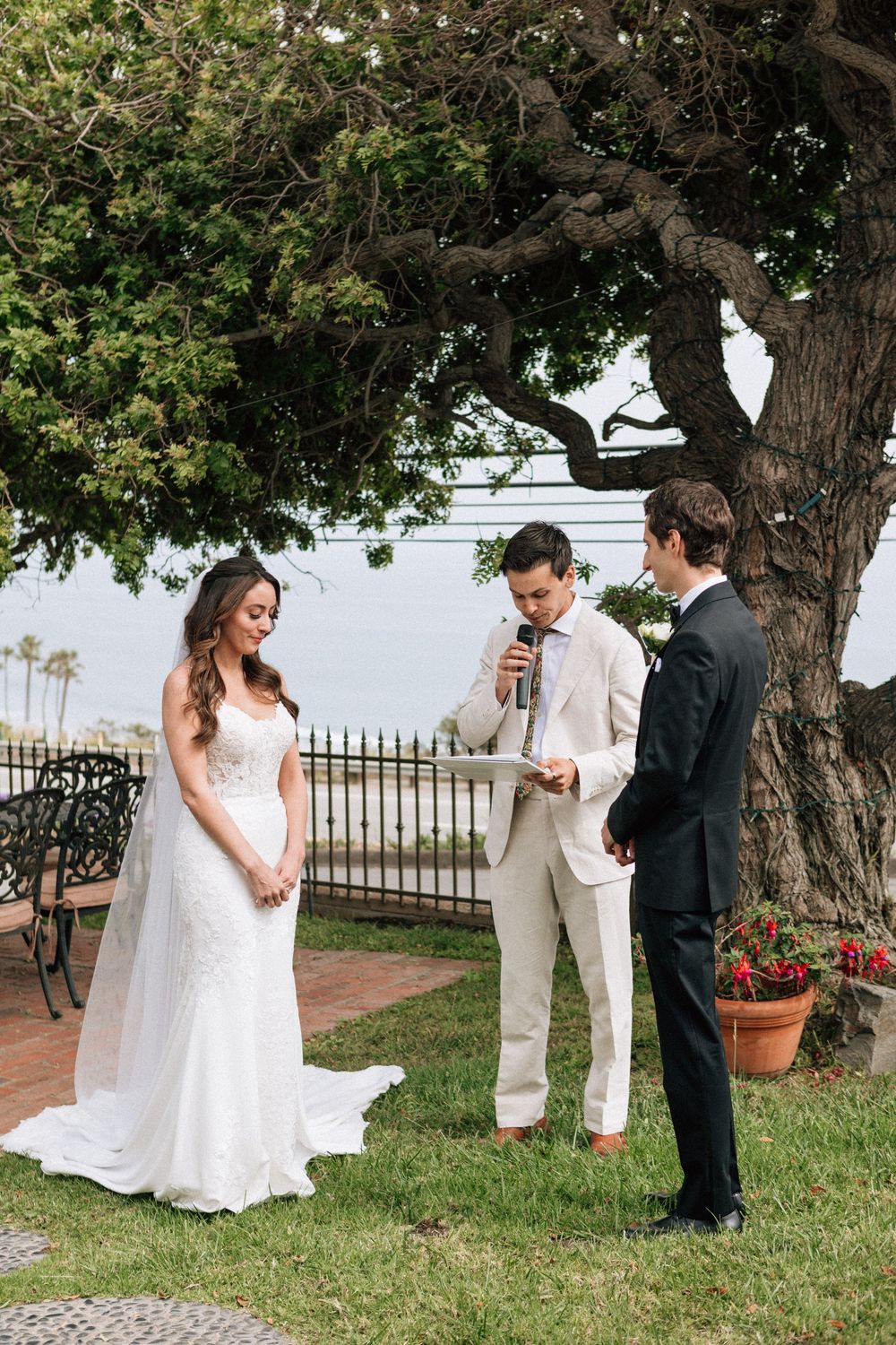35mm film photo of the couple bowing their heads before their Malibu ceremony.