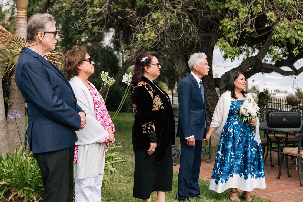 Malibu wedding photography of family watching a small ceremony on the Pacific Coast.