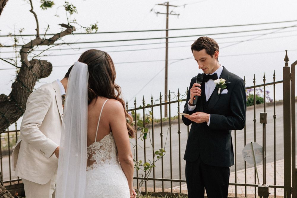Heartfelt moment of the groom sharing his vows during a Malibu wedding ceremony.