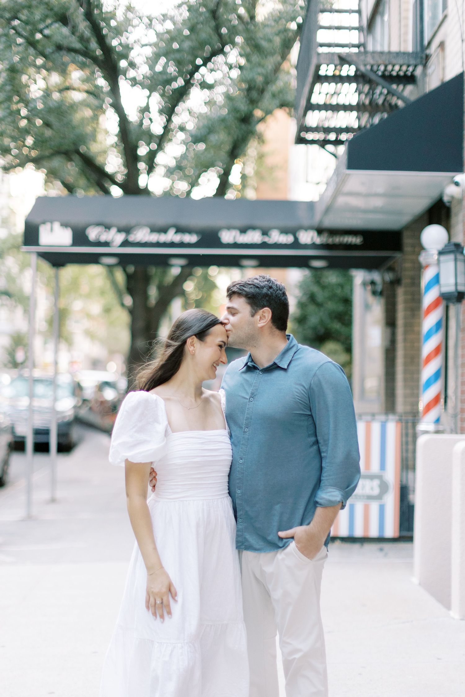 A romantic couple enjoying a casual stroll together outside a storefront on a bright sunny day.