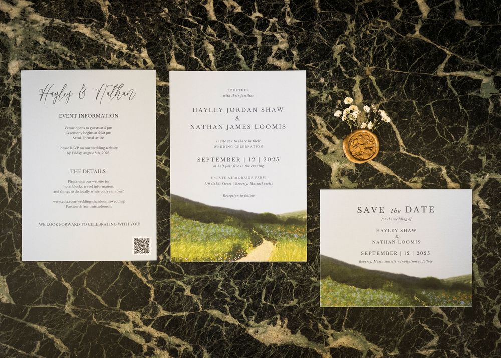 Collection of elegant wedding invitations and save the date cards laid out on dark marble background.