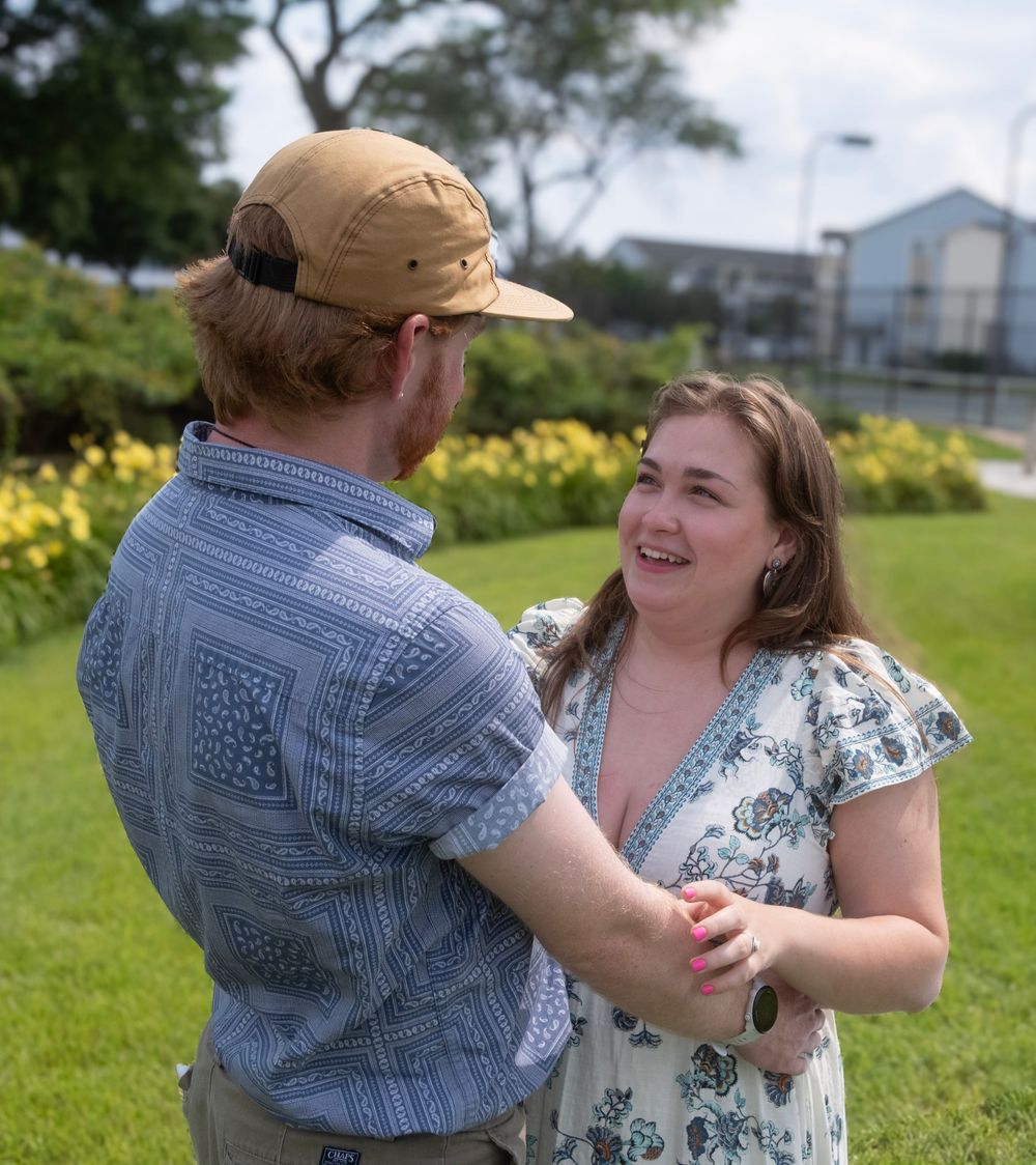 Loving couple sharing a joyful moment together in a grassy field with yellow flowers.