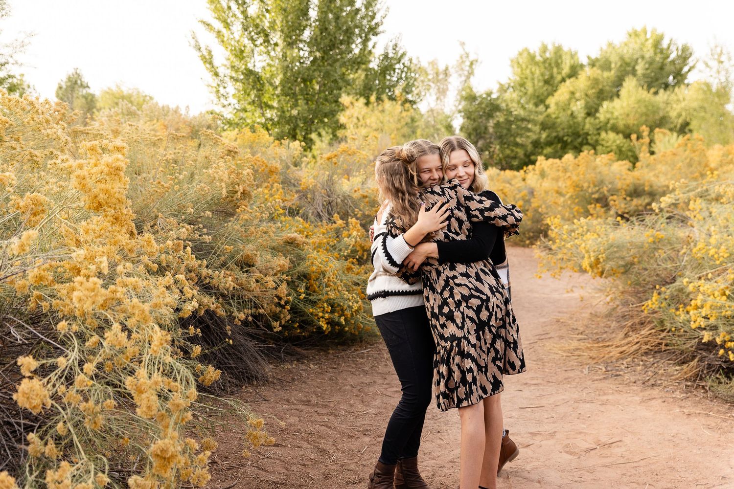 3 sisters hugging with beautiful yellow Desert blooms