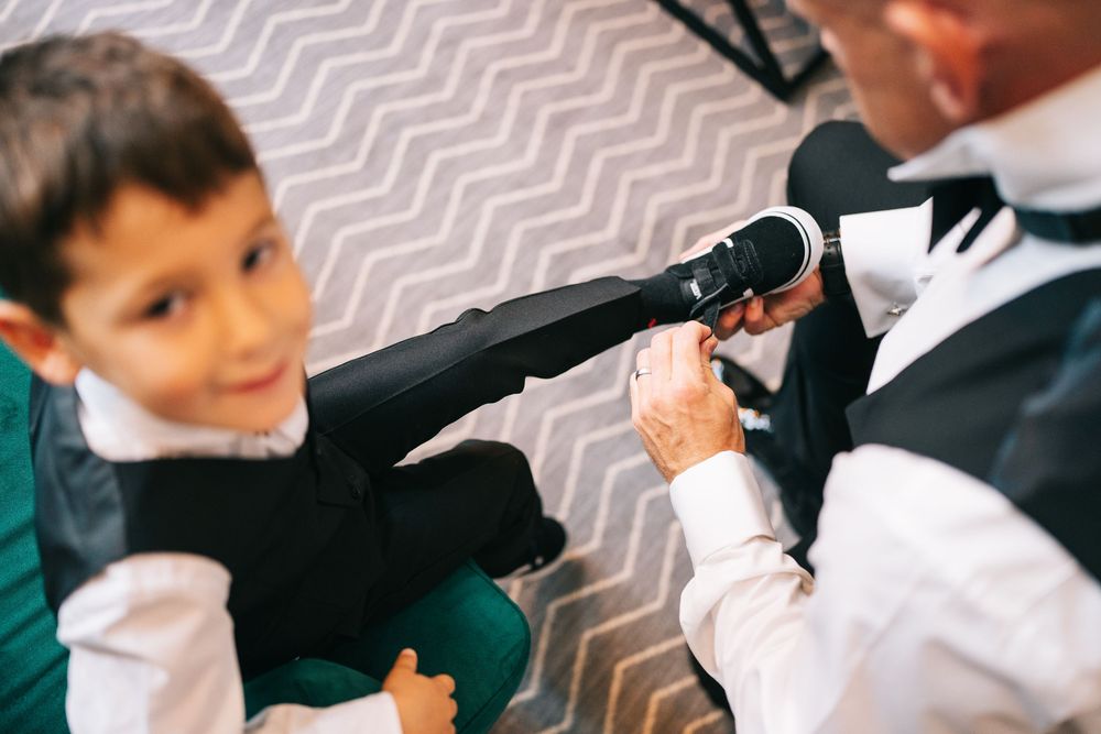 Students in a classroom follow along with their teacher showing pen movements and handwriting techniques.