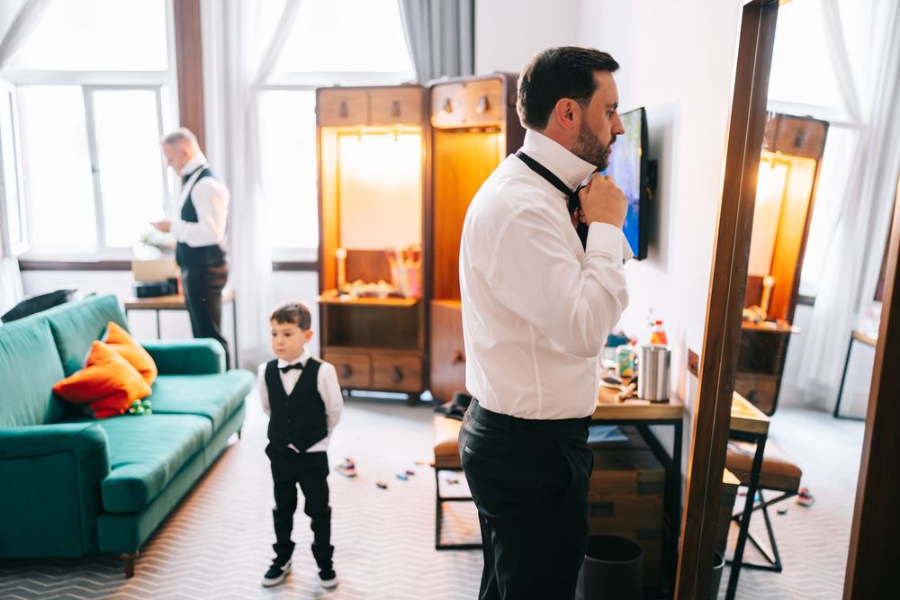 Getting ready in a bright apartment room with teal couch, wooden lockers and warm lighting.