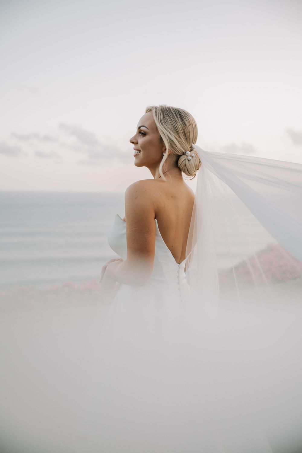 A bride in a white wedding gown and veil poses against a soft, ethereal background in a series of elegant portraits.