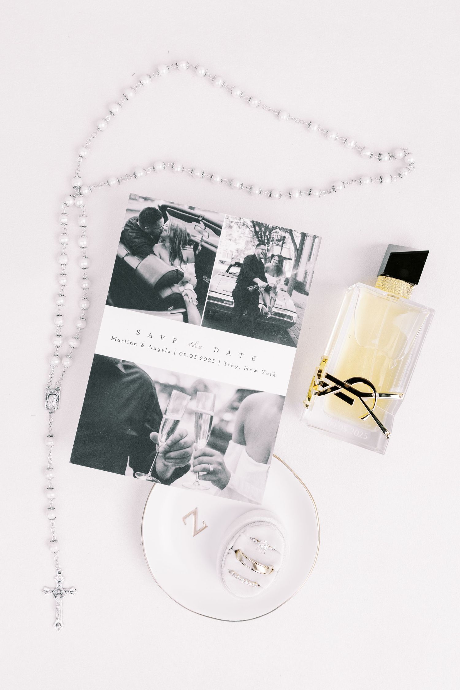 Black and white photographs arranged artistically with a candle and elegant decor items on a light textured surface.