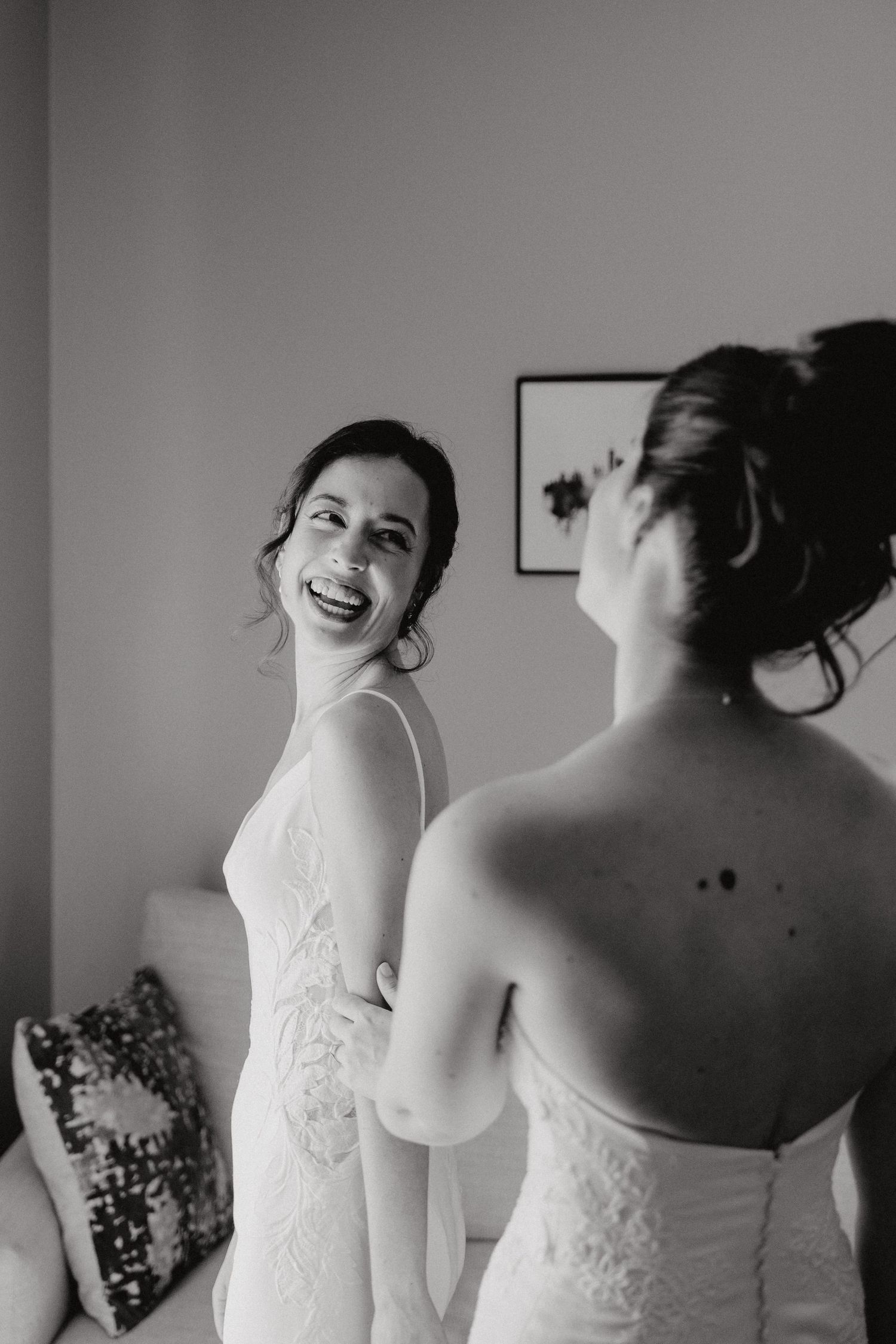 A black and white photo series showing candid moments of a bride laughing joyfully in her strapless white wedding dress.