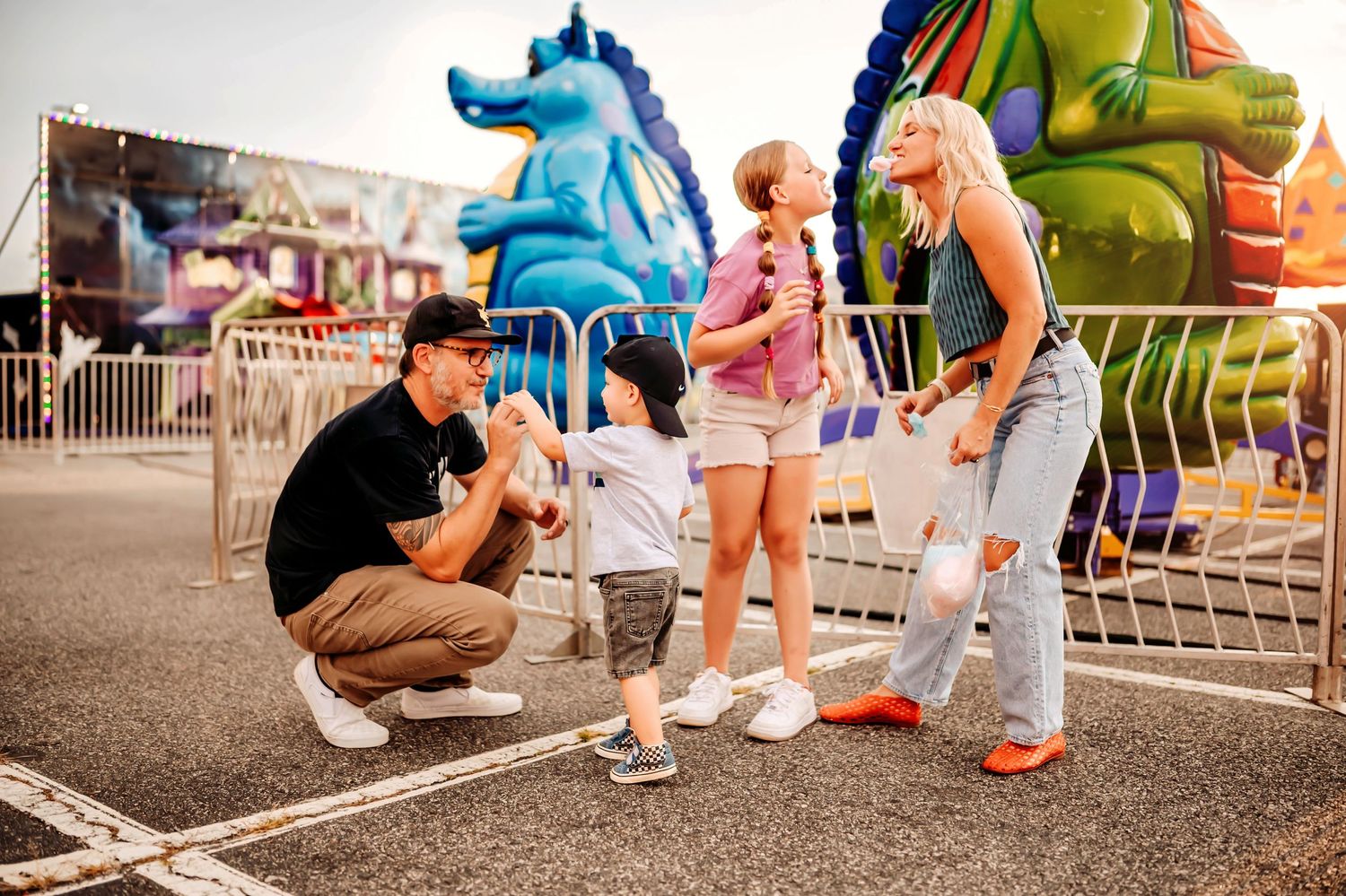 People interacting at a carnival with colorful inflatable decorations in the background.