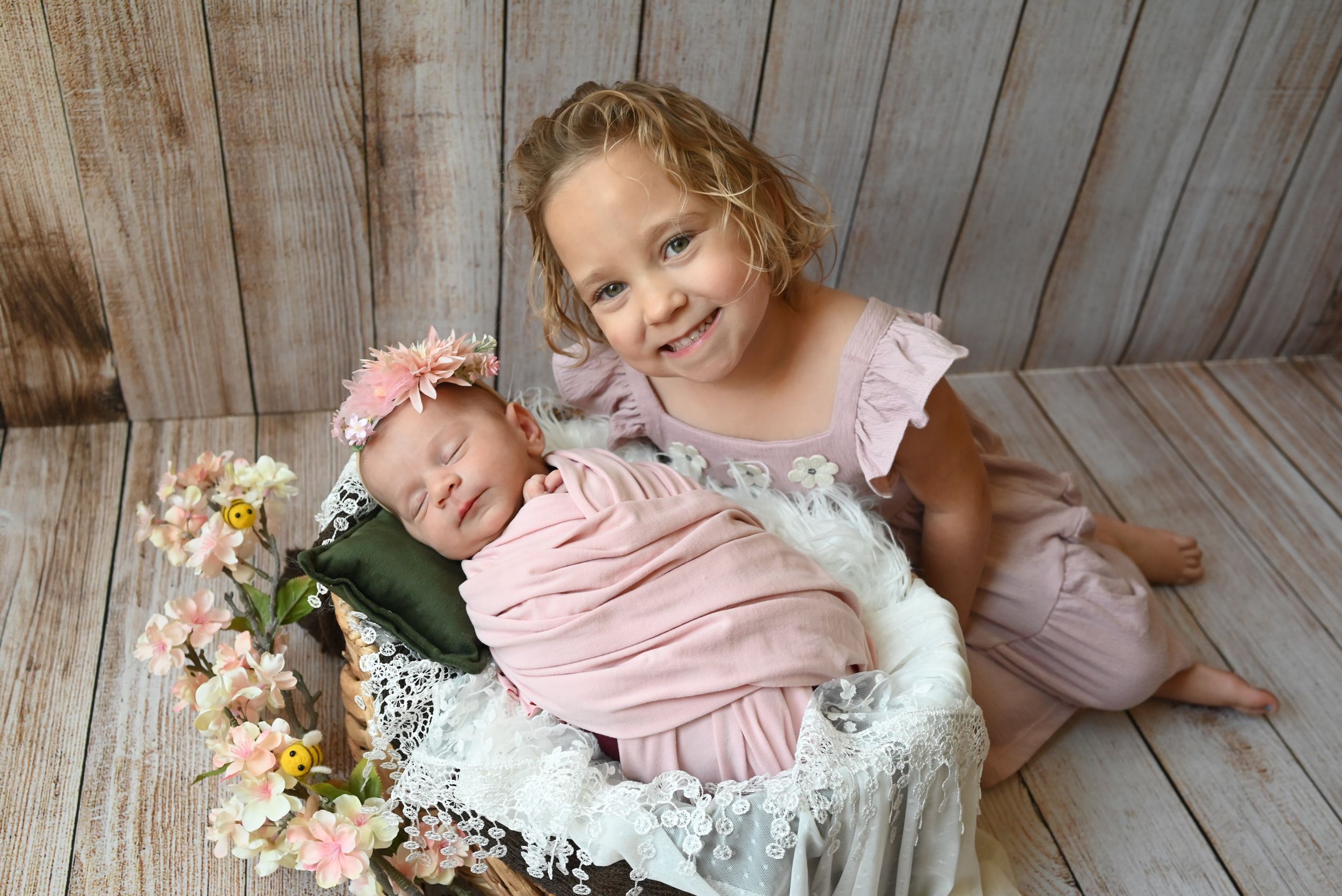 A rustic photo collage on wooden backdrop shows someone in pink outfit sitting with spring flower bouquets.